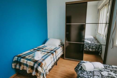 a small room with two beds and a closet at Ap completo melhor localização! Centro de Caxias. in Caxias do Sul