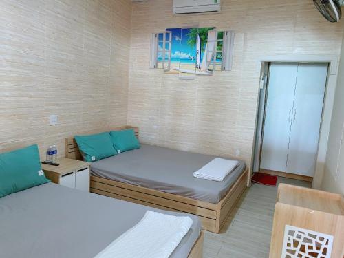 um pequeno quarto com 2 camas e uma janela em Khu du lịch Biển Cát em Ấp Long Sơn