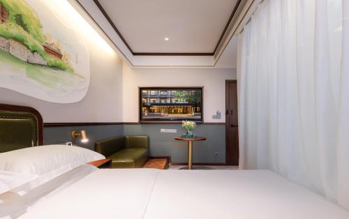 a hotel room with a white bed and a chair at Nost algia S Hotel Chengdu KuanZhai Alley & Renmin Park 时光漫步S酒店 成都宽窄巷子人民公园地铁站店 Free fresh ground coffee,Free laundry service in Chengdu
