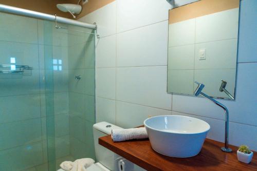 a bathroom with a sink and a glass shower at Apprezzare . Pousada beira-mar in Porto De Galinhas