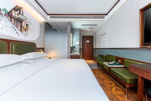 a bedroom with a large bed and a desk at Nost algia S Hotel Chengdu KuanZhai Alley & Renmin Park 时光漫步S酒店 成都宽窄巷子人民公园地铁站店 Free fresh ground coffee,Free laundry service in Chengdu