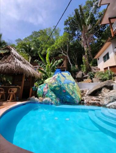 une piscine avec un grand rocher au milieu dans l'établissement Casa de Diamantes, à Tela