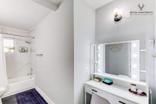 a white bathroom with a sink and a mirror at The Moose #6 - Modern Luxe Studio with Free Parking & King Bed in Memphis