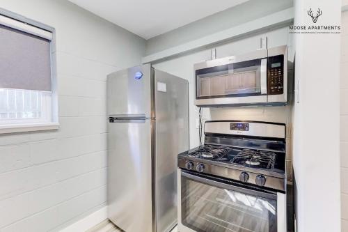 a kitchen with a stainless steel refrigerator and a microwave at The Moose #6 - Modern Luxe Studio with Free Parking & King Bed in Memphis