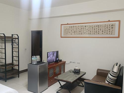 a living room with a television and a table at Yan Gui Lai B&B in Hengchun