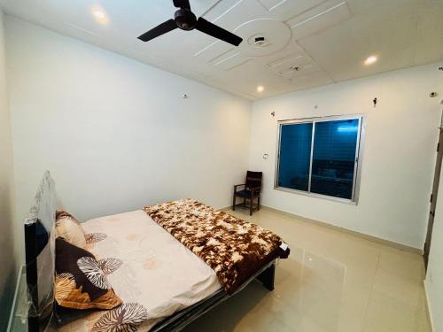 a bedroom with a bed and a ceiling fan at Atithi Dev Guest House in Ayodhya