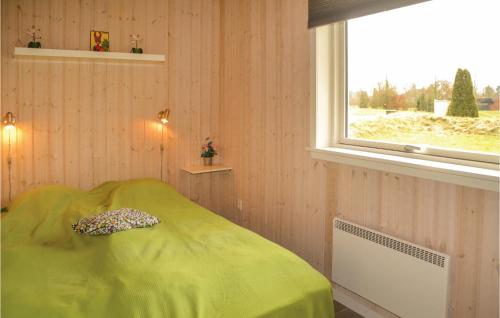 een slaapkamer met een groen bed en een raam bij Hugoline in Hovborg