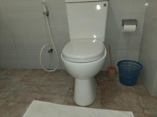 a white toilet in a bathroom with a roll of toilet paper at The Esence of Sri Lanka in Ahungalla
