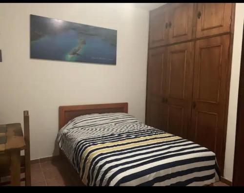a bedroom with a bed and a painting on the wall at VILLAS IXCHEL in Tapachula