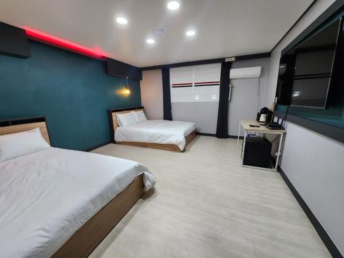 a hotel room with two beds and a television at Yuna Hotel by Merciel in Yeongcheon