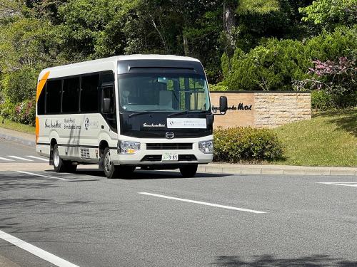 a white bus is driving down a road at Shima Kanko Hotel The Classic in Shima