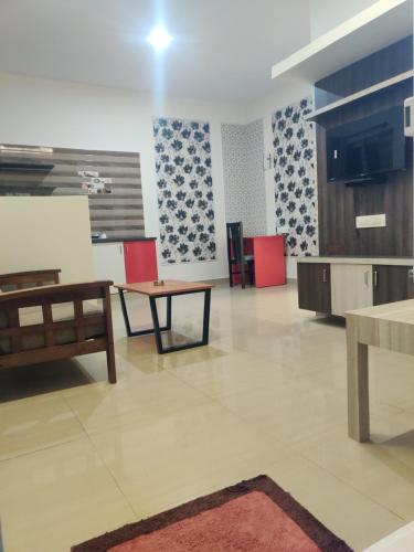 Il comprend un salon avec une table et des chaises ainsi qu'une cuisine. dans l'établissement VILASINI INN, à Bangalore