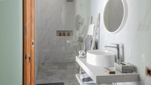 a white bathroom with a sink and a mirror at Calm Woods Villa Near Pandawa Beach in Nusa Dua