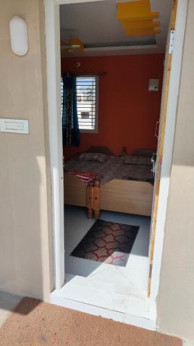 1 dormitorio con 1 cama en una habitación con ventana en Adhvan home stay, en Mysore