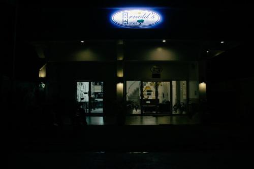 PoocにあるARNOLD'S HOTELの暗闇の中に青い看板のある建物