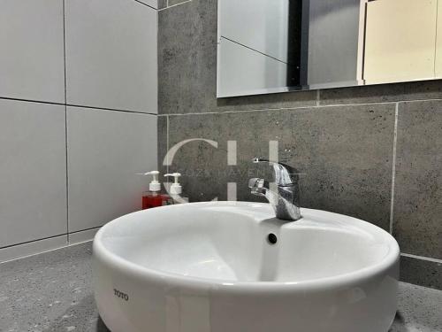 un lavandino bianco in un bagno con specchio di Kuching The Podium @ 4 Pax a Kuching