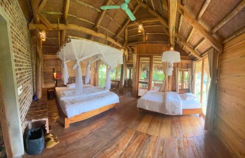 Habitación grande con 2 camas y suelo de madera. en Chez Thuc Home’stay, en Thanh Hóa