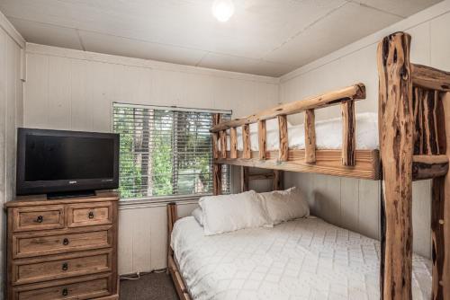 a bedroom with a bunk bed and a flat screen tv at Cozy Townhome with Wildlife Views! 5-min walk to Midtown! Modern Look in Ruidoso