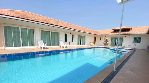 a swimming pool in the middle of a house at Home JANO in Cha Am