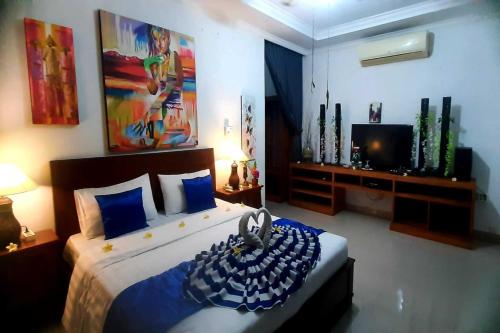 een slaapkamer met een groot bed en een televisie bij Tranquil Oasis Villa Near Lovina Beach in Temukus