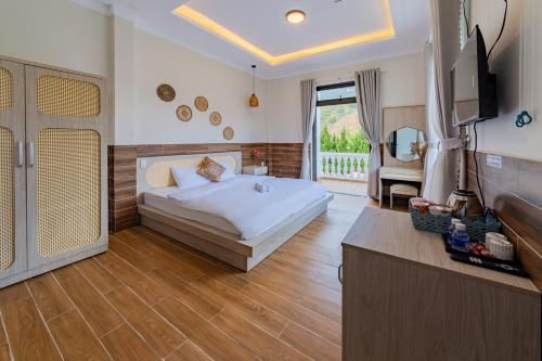 ein Schlafzimmer mit einem Bett und einem TV in der Unterkunft WHITE HOUSE in Ấp Ðinh An (1)