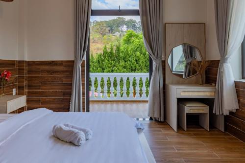 a bedroom with a bed and a mirror and a sink at White Villa Đà Lạt in Da Lat