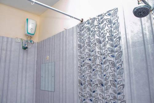 een douche met een douchegordijn in de badkamer bij Nyali Sea View 4 Beds Apartment With Pool in Mombasa