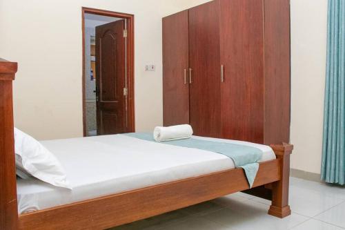 een slaapkamer met een bed en een houten kast bij Nyali Sea View 4 Beds Apartment With Pool in Mombasa