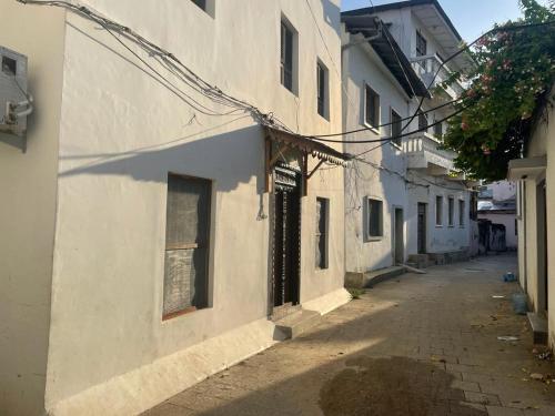 an alley with a white building and a street at Four Seasons in Stone Town