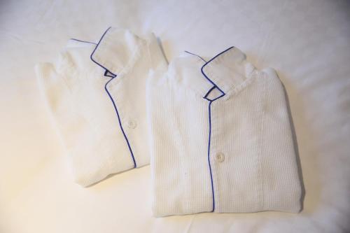two white shirts are sitting on a bed at KYOTO GION HOTEL in Kyoto