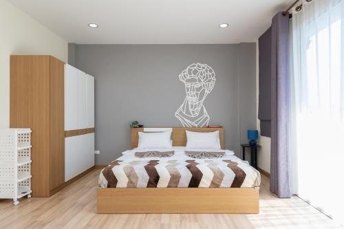 a bedroom with a bed and a wall with a drawing at AreeHouse 曼谷 300平方 獨棟別墅 家庭首選 近7-11 超市 MRT in Bangkok