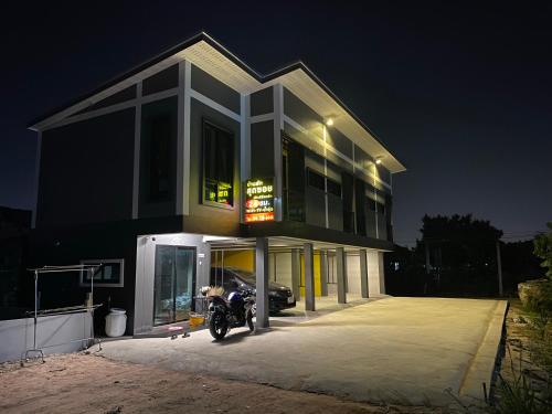una moto parcheggiata di fronte a un edificio di notte di บ้านพักสุดซอย a Ban Rai