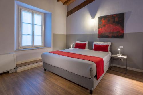 a bedroom with a large bed with red pillows at Hotel Cortaccia Sanvitale in Sala Baganza