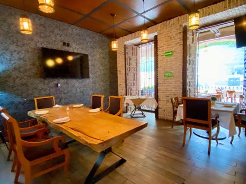 uma sala de jantar com uma mesa de madeira e cadeiras em Hotel Plaza D Armas em Querétaro
