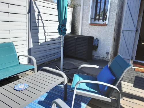- 2 chaises, une table et un parasol sur la terrasse couverte dans l'établissement Bord Verdon T2 Maisonnette 35m2 Climatisation - Terrasse 25m2-classé 3étoiles, à Gréoux-les-Bains