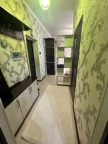 een badkamer met groene muren en een hal met planken bij Center Cozy Apartment in Bisjkek