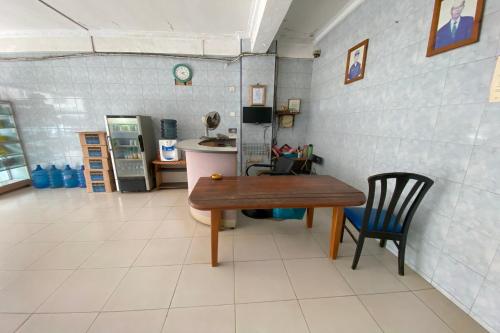 a kitchen with a table and a chair in a room at OYO 93781 Hotel California 2 in Bagam