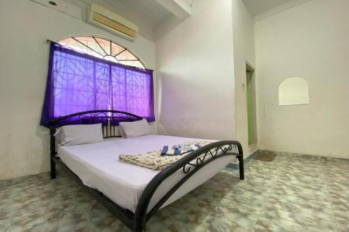 a bedroom with a bed with a purple window at OYO 93781 Hotel California 2 in Bagam