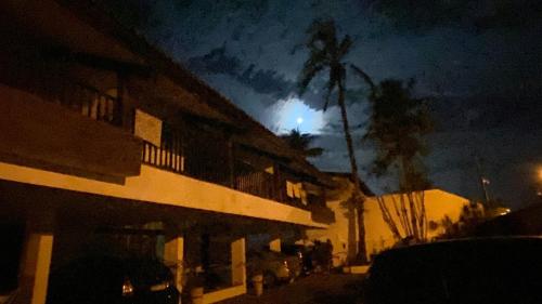a building with a moon in the sky at night at Royal-inn SPA & Pousada in Itanhaém