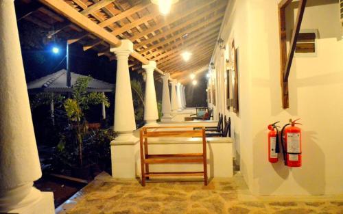 eine Veranda mit weißen Säulen und eine Treppe mit zwei Hydranten in der Unterkunft Lihini Scandic Eco Village in Habarana