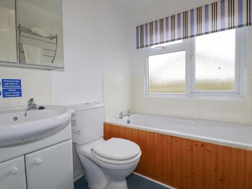 a bathroom with a toilet and a sink and a tub at Summer Breeze in Padstow