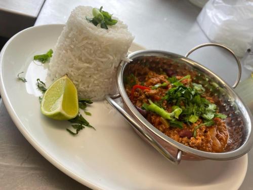 a plate of food with rice and a pot of food at The Open Ditch Apartment in Worcester