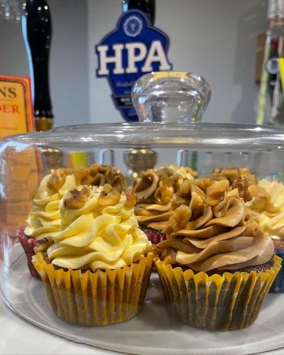 two cupcakes on a plate in a glass case at The Open Ditch Apartment in Worcester