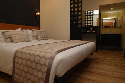a bedroom with a large bed and a bathroom at HOTEL SR in Palni