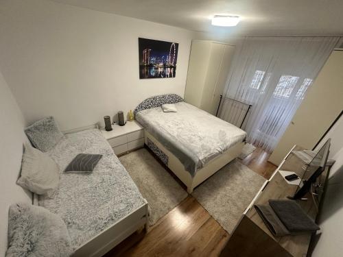 a small bedroom with a bed and a couch at ENE Apartament Oradea in Oradea