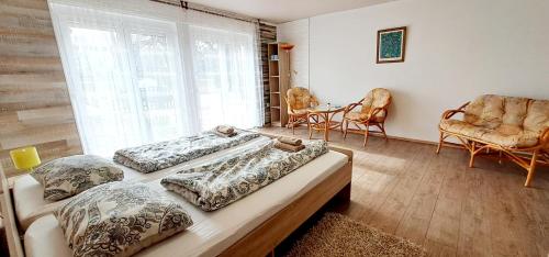 Habitación con 3 camas, sillas y ventana en Napvirág - Közel mindenhez en Balatonakarattya