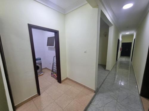 a hallway with a mirror and white walls and a hallway with a doorway at B's Classic and Cozy Apartments in Cape Coast