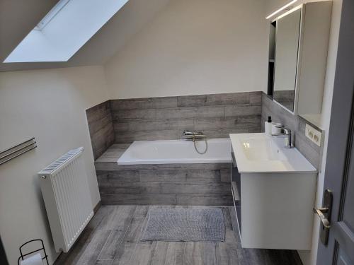 a bathroom with a bath tub and a sink at Les gîtes du Ravel in Soignies