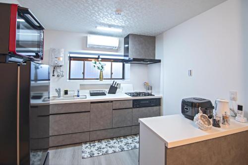 a kitchen with a sink and a stove top oven at - UMI-Haven 福島 - 隣駅5LDK戸建 in Osaka