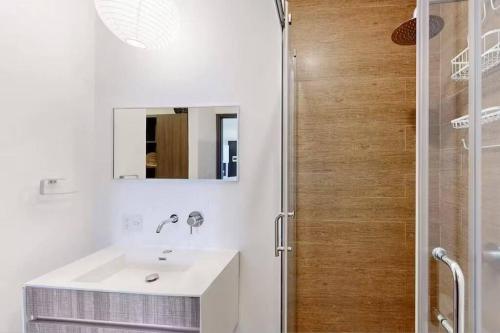 uma casa de banho branca com um lavatório e um chuveiro em Comfortable and cozy loft with pool - Alure em Cidade do México